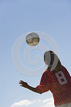 Young Woman Heading Football