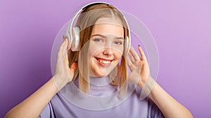 Young woman in headphones with beautiful smile blonde hairstyle portrait. Teenager girl enjoy listen song music moving