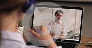 Young woman in headphones holding job interview online.