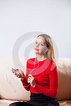 Young woman in headphones listening music relaxing at home on so