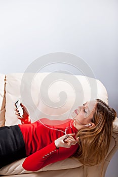 Young woman in headphones listening music relaxing at home on so