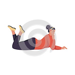A young woman with headphones is lying on the floor