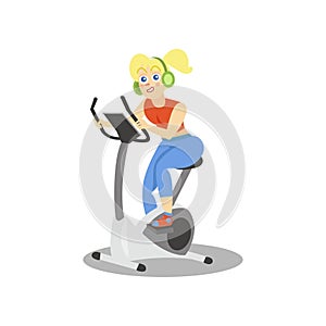 Young woman in headphones training on an exercise bike, girl working out in the fitness club or gym, active healthy