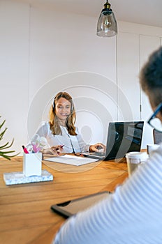 Young woman with headset in customer service of coworking