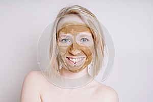 Young woman with healing earth or clay beauty facial mask
