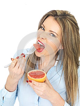 Young Woman Healthy Eating a Pink Grapefruit