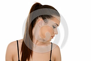 Young woman with healthy shining brown hairs put in pony tail.