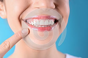 Young woman with healthy teeth and beautiful smile on color background