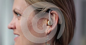 Young woman and hearing aid on ear