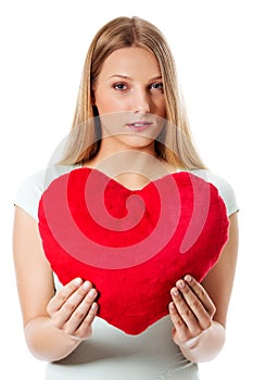 Young woman with a heart pillow in her hands - Valentines day concept.