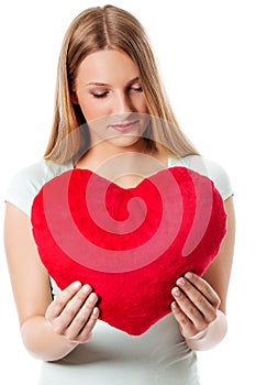 Young woman with a heart pillow in her hands - Valentines day concept.