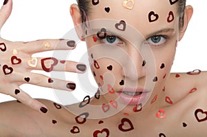 Young woman with hearts on face and hand