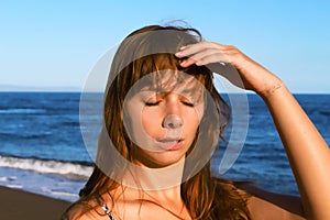 Young woman with heatstroke. Sunstroke on a beach. Healthy lifestyle on vacation photo