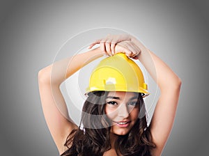 Young woman with hellow hard hat against gradient