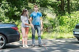 Young Woman Helping Blind Man photo