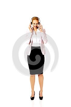 Young woman helpline operator is trying to hear something through headphones