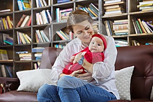 Young woman and her baby daughter on couch in library