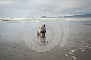 Young woman and her Border Collie dog together on a Northern California beach