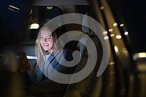 Young woman with her cell phone sitting in  car