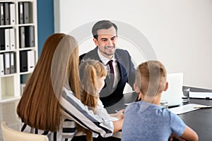 Young woman and her children meeting with headmaster at school photo