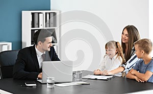 Young woman and her children meeting with headmaster at school photo