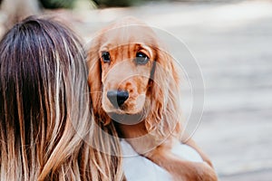 young woman and her cute puppy of cocker spaniel outdoors