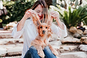 young woman and her cute puppy of cocker spaniel outdoors. Funny dog big ears