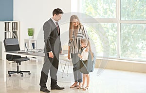 Young woman and her daughter meeting with headmaster at school photo