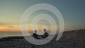 Young Woman And Her Daughter Sit On The Ocean Coast With Lights