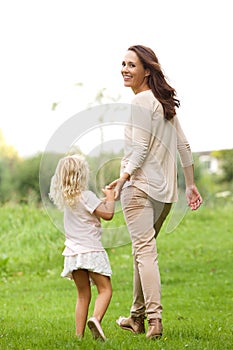 Young woman with her daughter walking in park