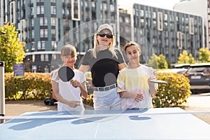 Young woman with her daughters playing ping pong in park