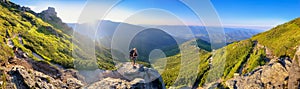 Young woman and her dog on mount Vuhaty Kamin. Panorama. Chornohora ridge, Carpathian mountains, Ukraine.