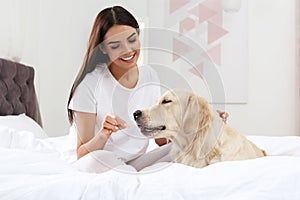 Young woman and her Golden Retriever dog on bed