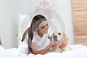 Young woman and her Golden Retriever dog on bed