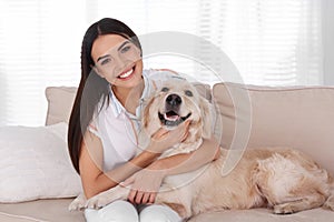 Young woman and her Golden Retriever dog on couch in room