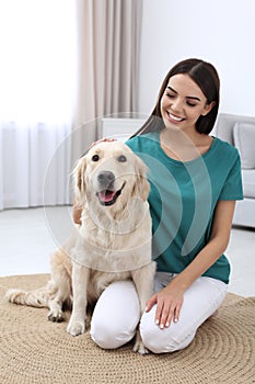 Young woman and her Golden Retriever dog in room