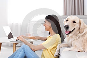 Young woman and her Golden Retriever dog in room