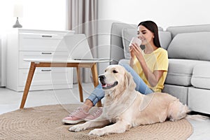 Young woman and her Golden Retriever dog in room