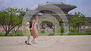 Young woman and her little son visit ancient palace in Seoul, South Korea. Travel to Korea concept. Slowmotion shot