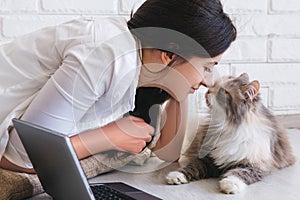 Young woman and her lovely cat rubbing noses