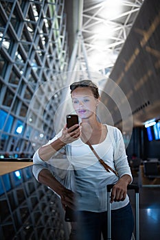 Young woman with her luggage at an international airport