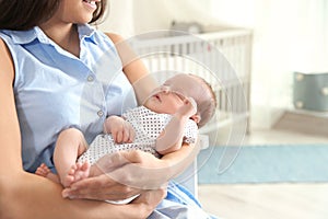 Young woman with her newborn baby at home, closeup.