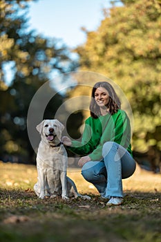 Young woman and her obedient big dog in autumn park