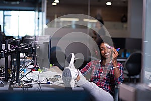 Young woman at her office workplace playing with plane toy