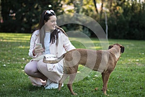 Young woman with her pet dog in the park