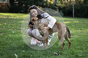 Young woman with her pet dog in the park