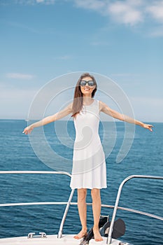 Young woman on her private yacht at sunset