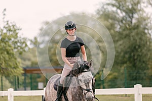 Young woman and her red horse during a calm trail ride