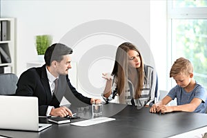 Young woman and her son meeting with headmaster at school