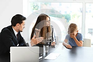 Young woman and her son meeting with headmaster at school